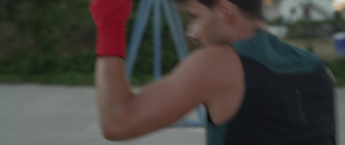 A man wearing red gloves is practicing fighting moves