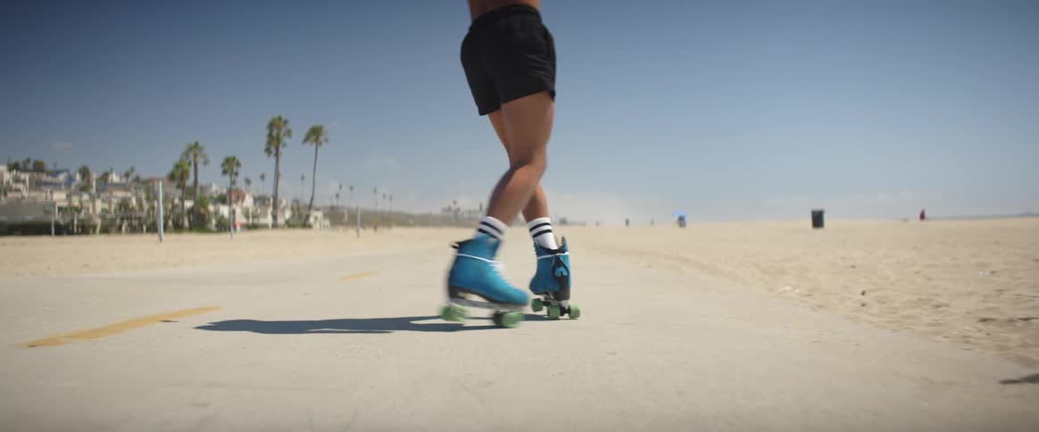 A dancer rollerskating on the beachside promenade on a summer day