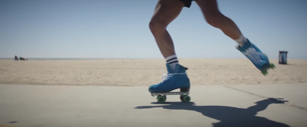 Man in shorts roller skates near the beach