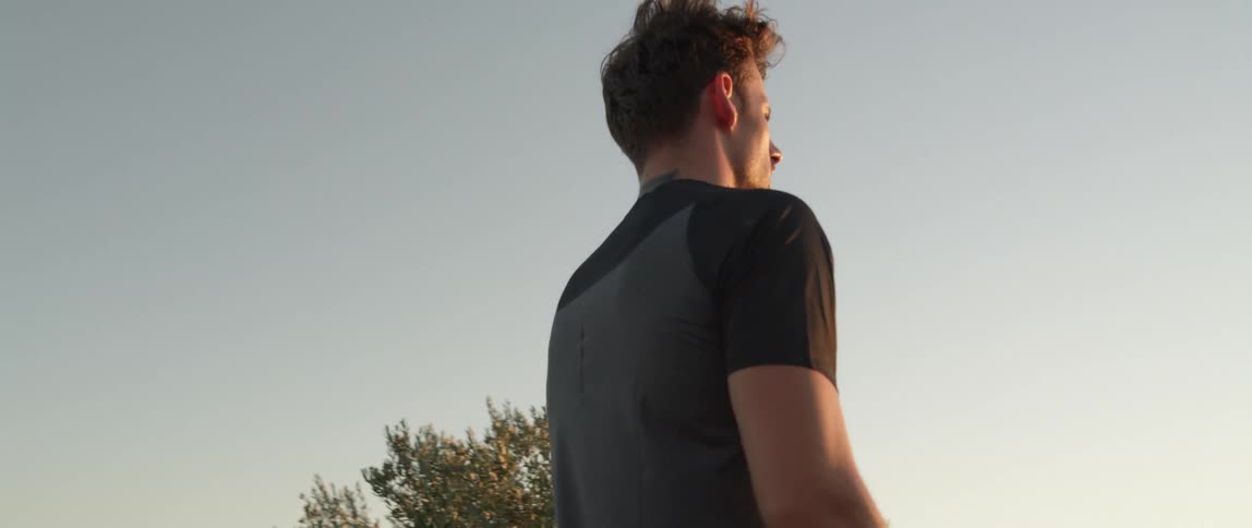 A man shouts and holds his arms outwards while standing outdoors