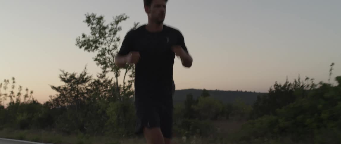 A man running on a natural road at dawn
