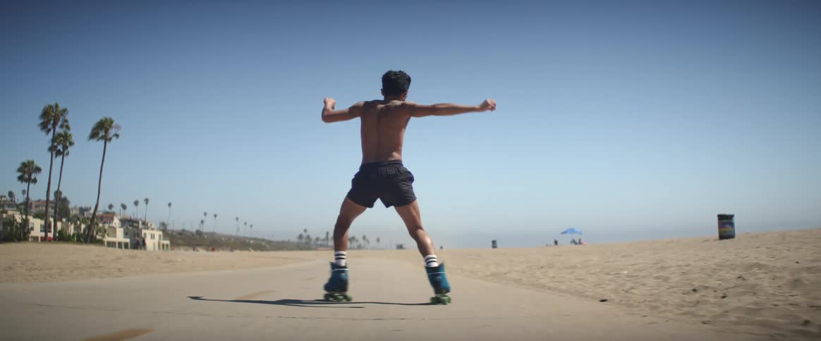 A man is rollerblading along the shore
