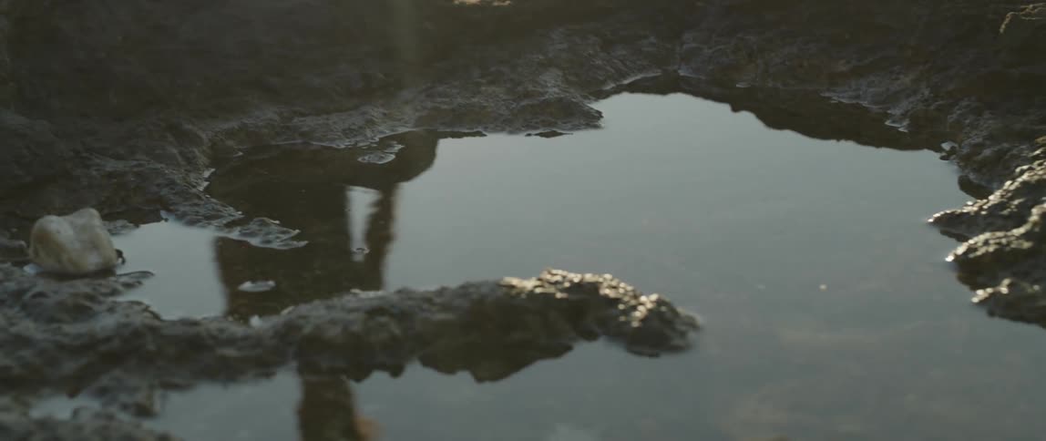 A man running on the rocks at the beach