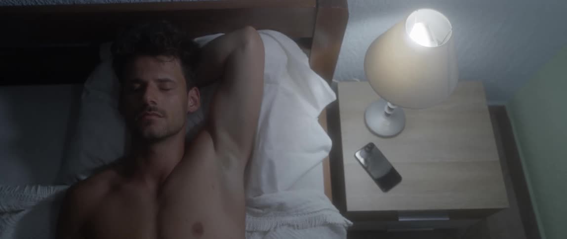 A thoughtful man lying on the bed in the dark room
