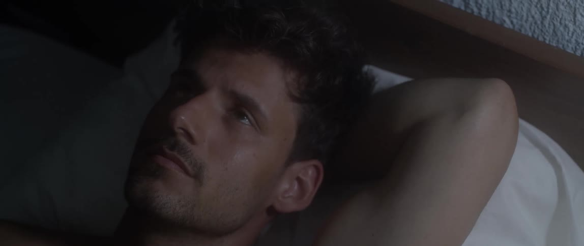 A man lying awake in bed at night