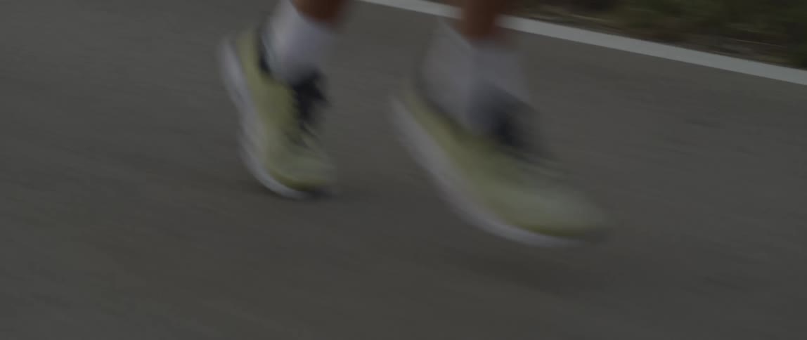A man is shown from the bottom up while jogging outside