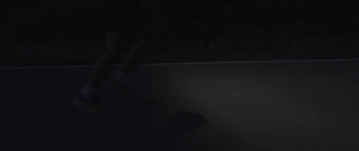 Silhouette of a man running on a road in the desert at nightfall