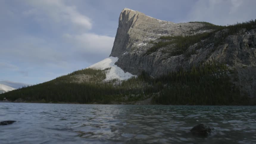 The water is rough  near the shore of this mountain