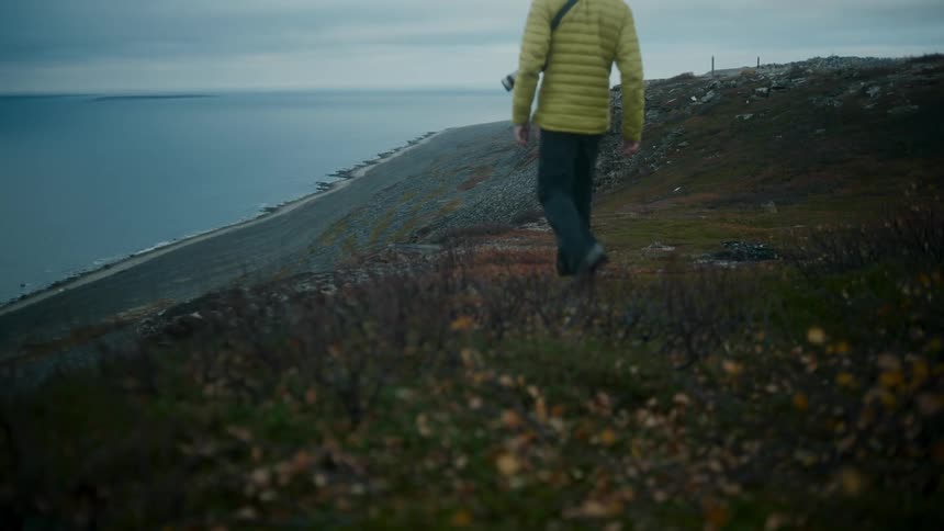A man walking on the beach slope during the cold day