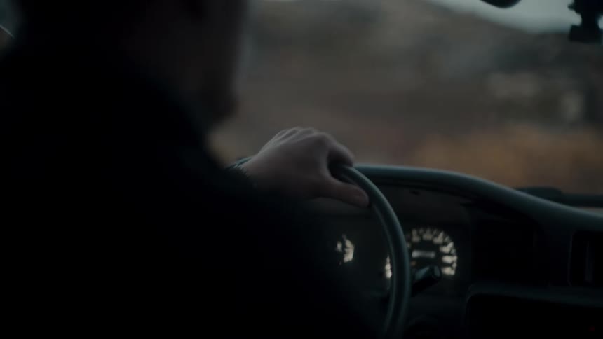One hand on a car steering with dashboard