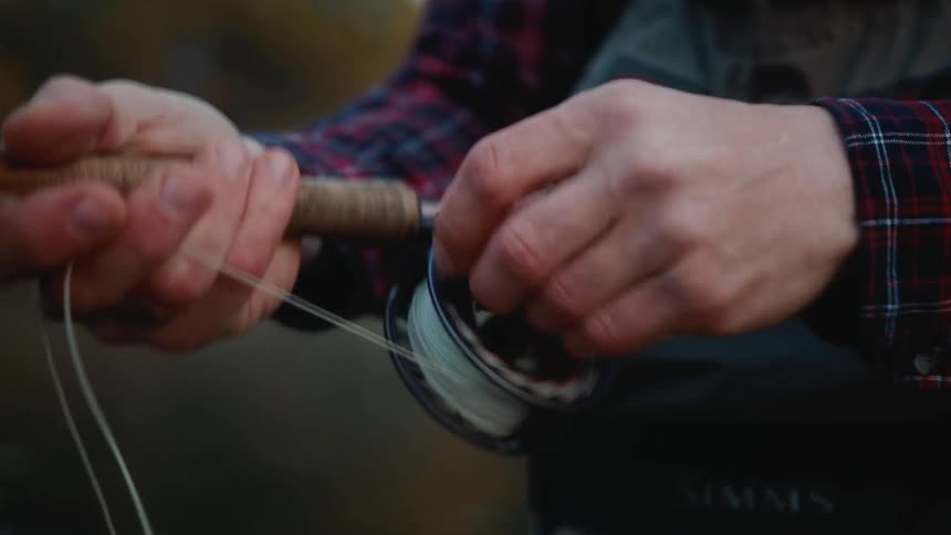 A man is reeling in his fishing rod
