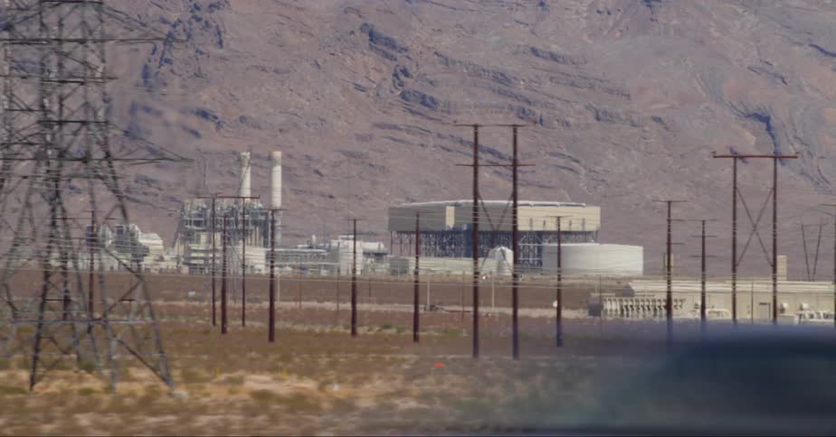 An energy treatment plant in a desert and several poles in front