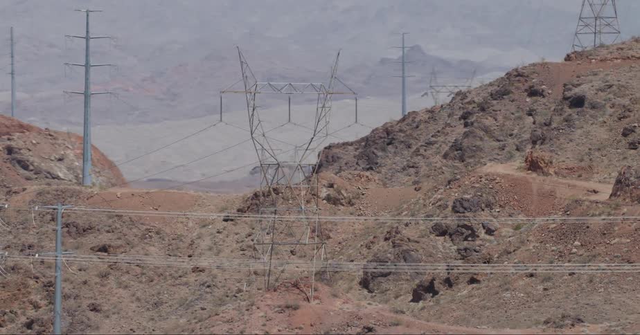 An aerial of an electrical power station and power lines set in a dry mountain range