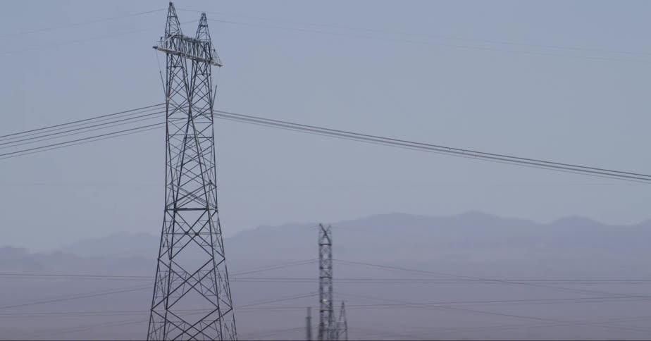 Transmission poles with wires at midday