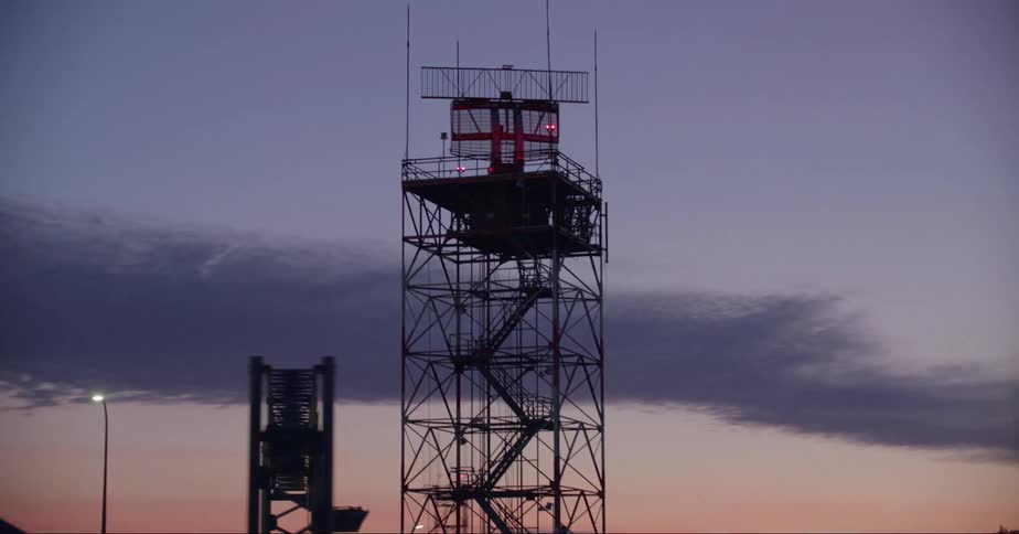 A radio tower with a red satellite dish rotating