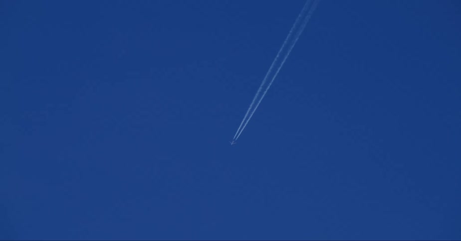 Jet flies through sky leaving dual contrail