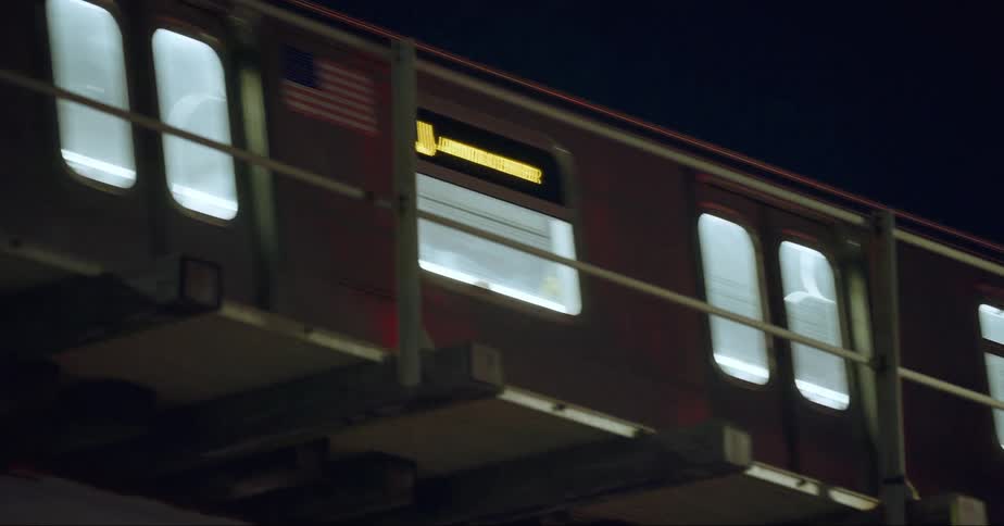 Metro moves along raised tracks at night