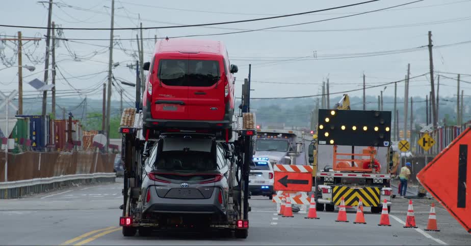 A stork truck transporting cars around the city