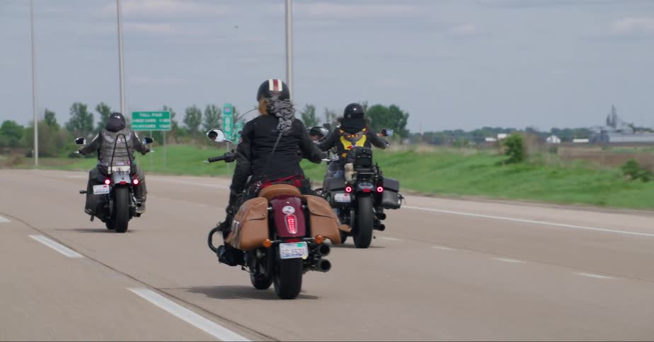 Group of motorcycles ride down highway