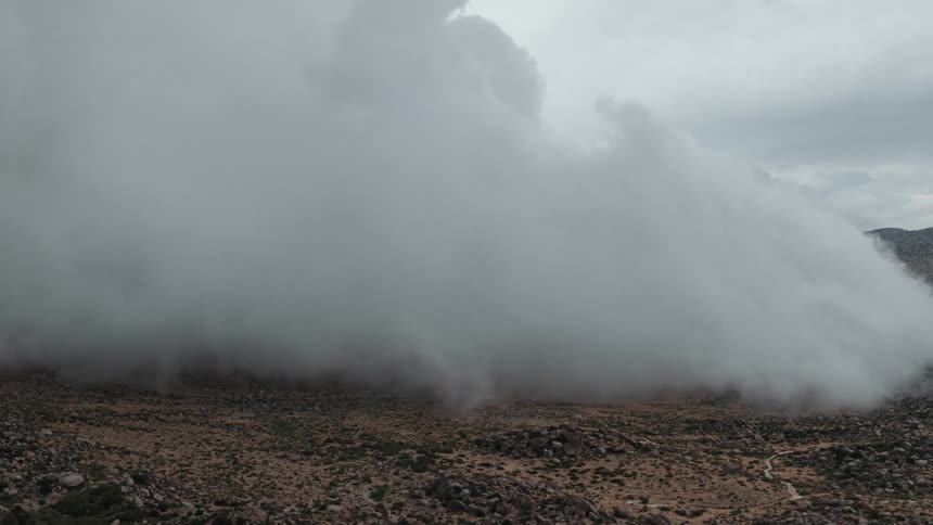 The clouds flow over the field