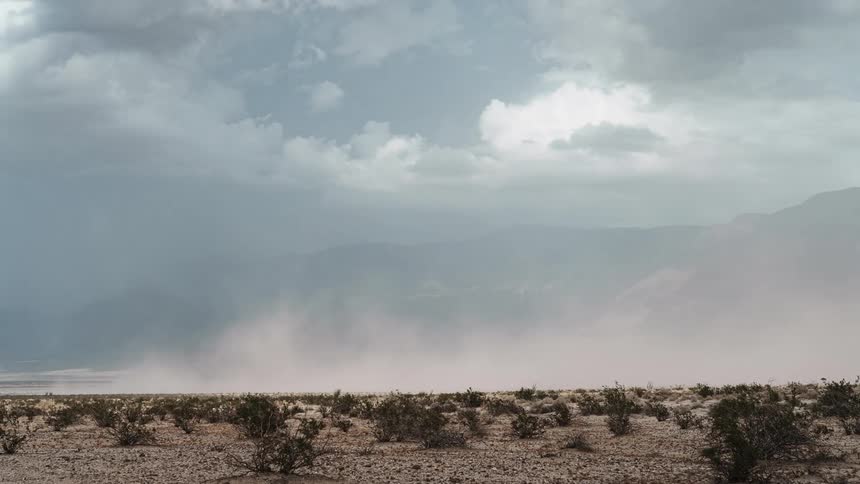 Mountain range covered in vegetation and dusty winds