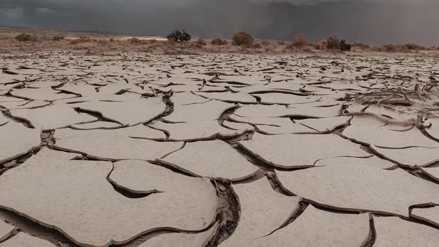 Storm clouds floating over parched and brown land