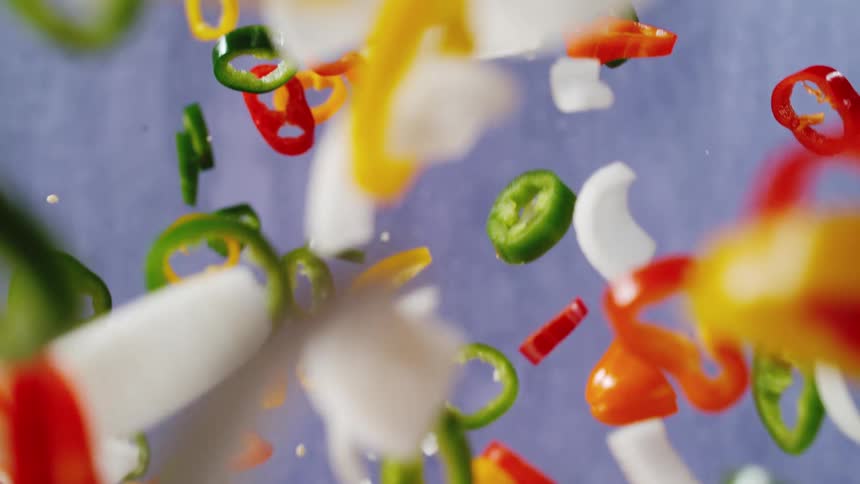Vegetables like peppers and onions sliced in free fall in slow motion