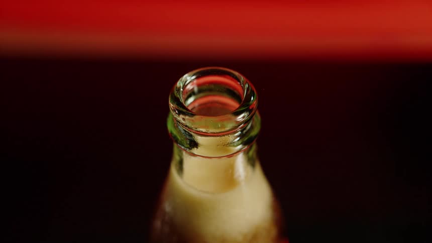 A glass soda bottle with foam