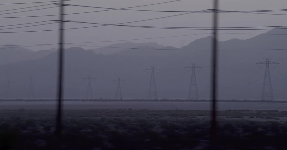 Utility poles and power lines in front of a mountain