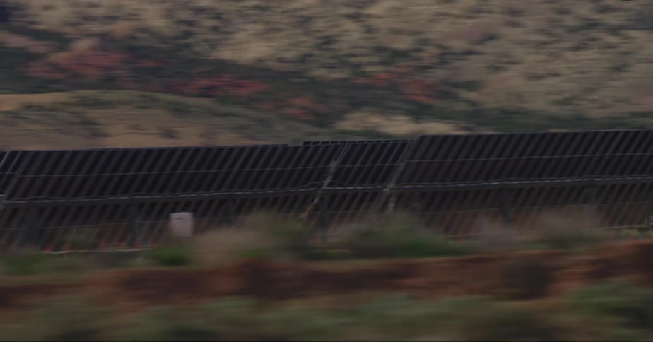 Vehicle driving on road near the solar panels