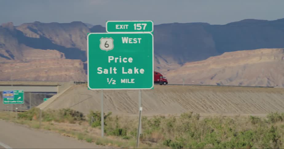 A truck crossing an overpass over a desert highway