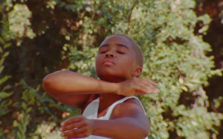 A black lady in an underwear stretching her arms