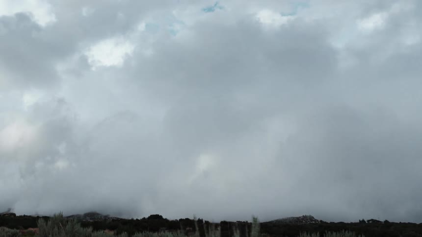 Time lapse of thick white clouds rolling over the countryside