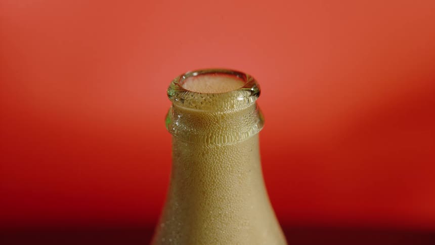 Close up of soda foam bubbling inside the neck of a bottle