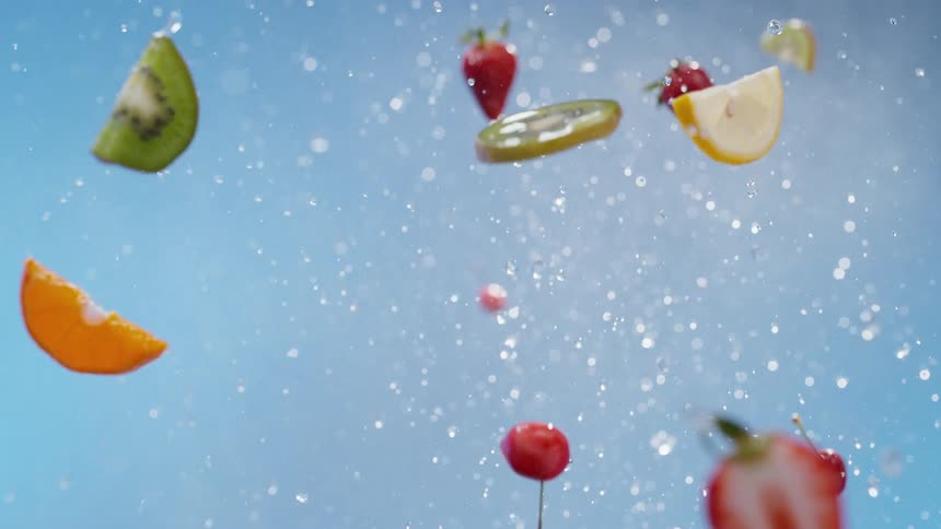 Lemon kiwi orange and strawberry slices being tossed upwards