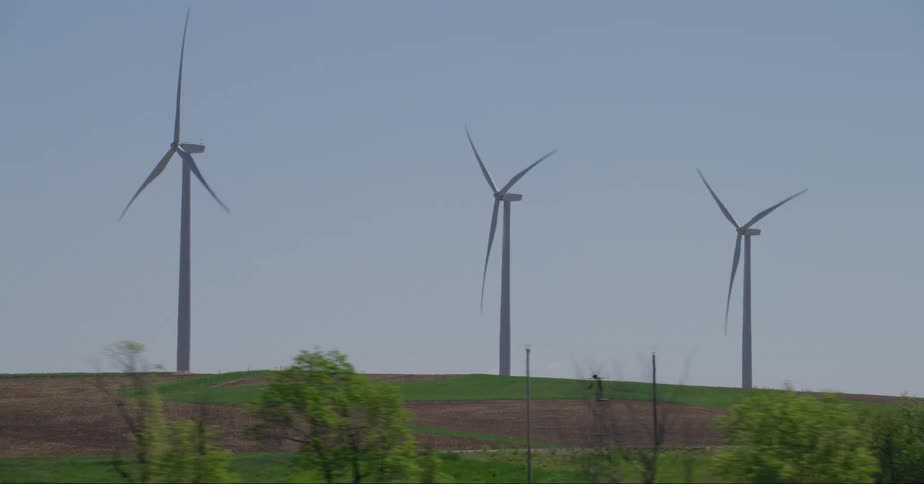 Wind turbines and passing vehicles on a sunny day