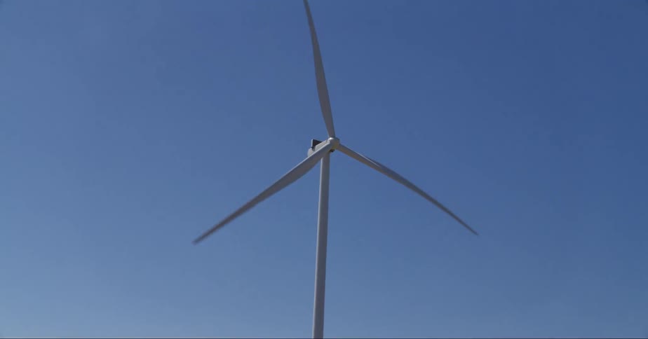 Vehicle moves along road passing wind farm