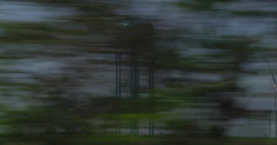 A water tower is behind the windmills