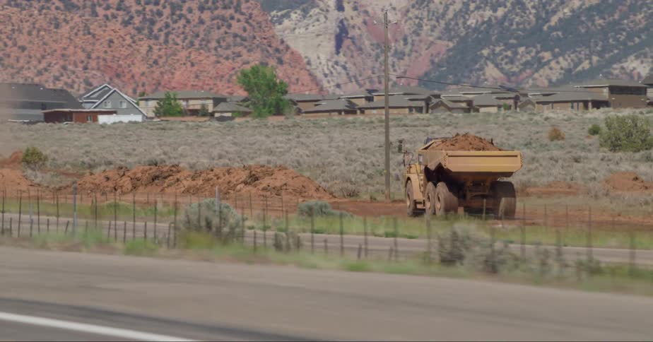 A truck with a dump bed carrying soil