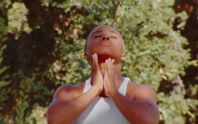 A young woman dancing with her hands in an outdoor setting