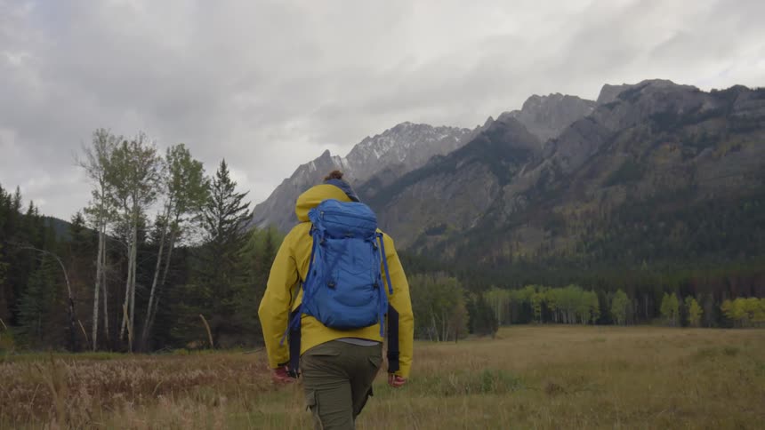A man is hiking towards a mountain ahead