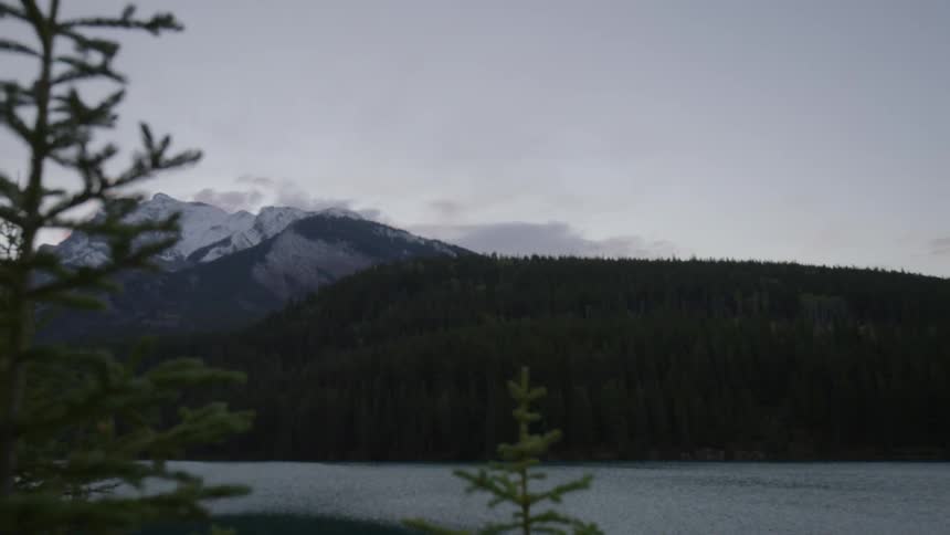 A lake leads to a snow covered mountain