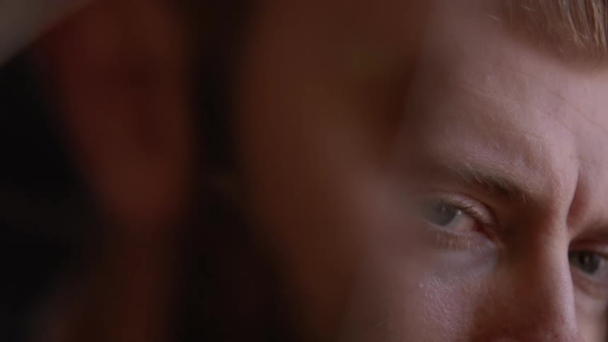 Man turns his eyes to stare while leaning on his hand