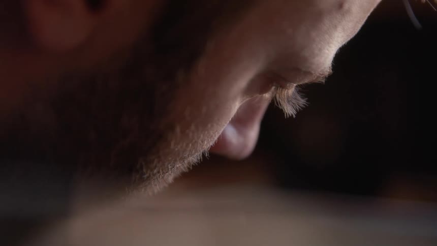 A closeup of the side of a bearded mans face