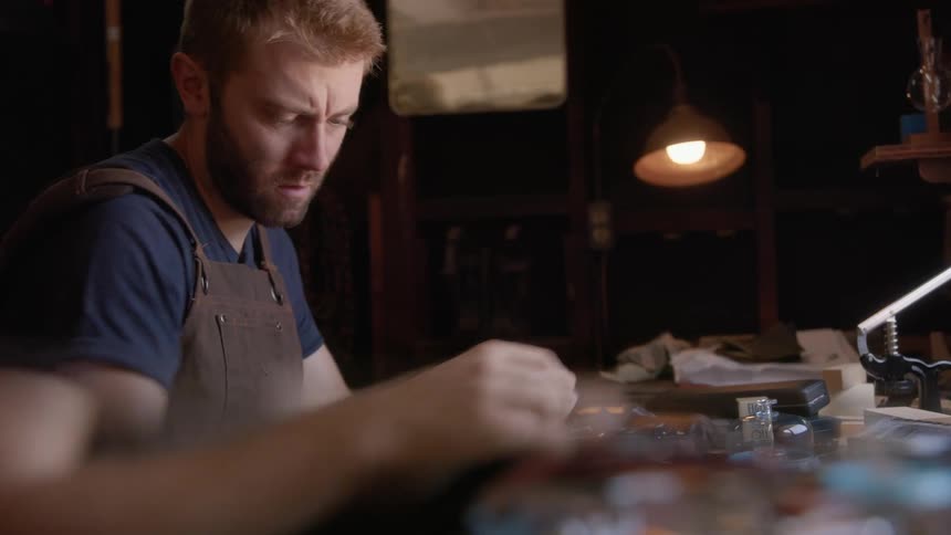 A man concentrated on repairing a piece of jewelry