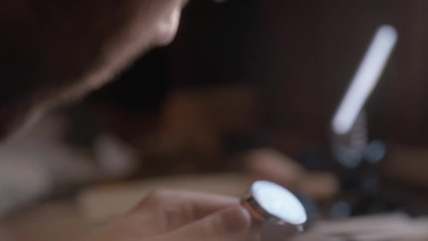 A man holding and staring at a wristwatch