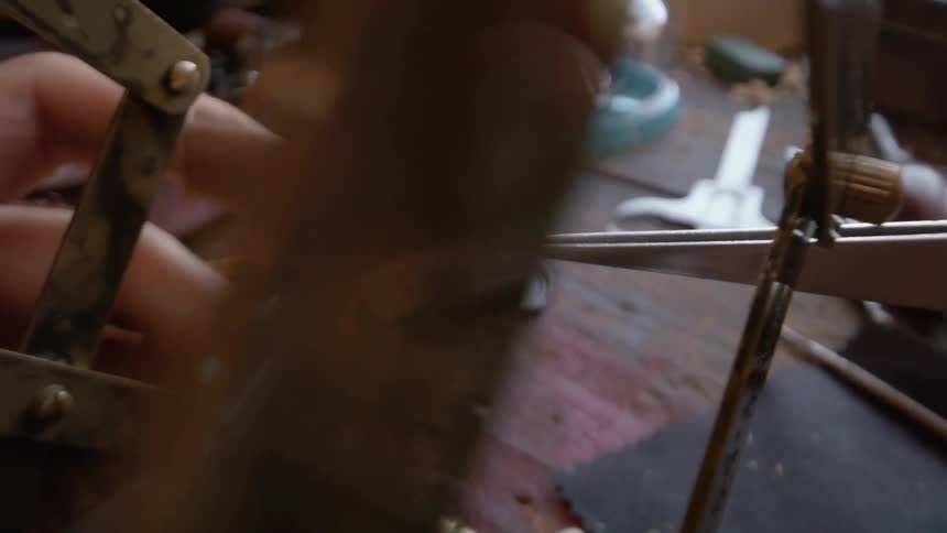 Person looks at a small pin through a magnifier