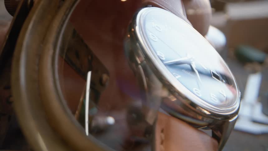 A closeup of a wristwatch examined under a magnifying glass