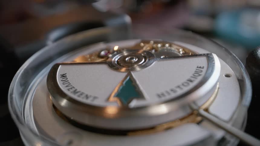A mechanical watch is partially disassembled as its gears turn