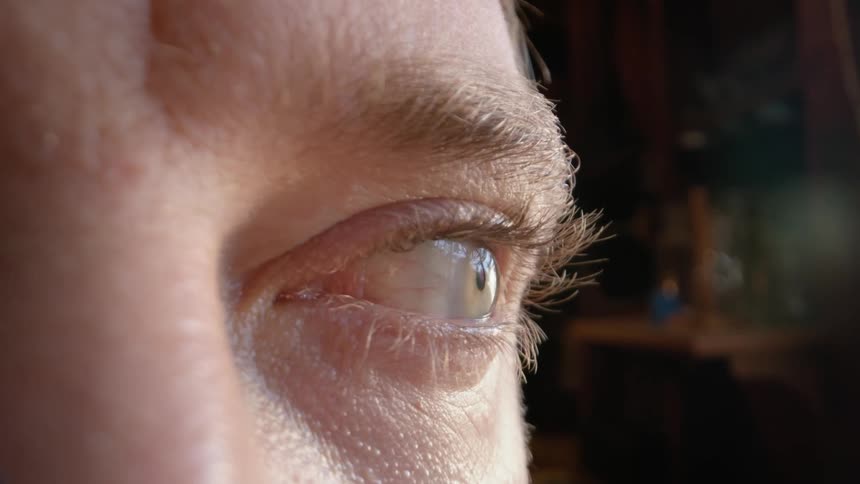 Close up of the green eyes of a man looking around